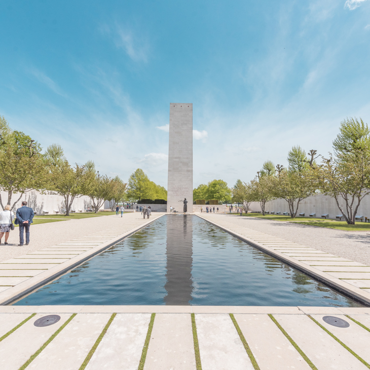 Aanzicht van hoog rechthoekig monument met daarvoor waterpartij op Amerikaanse Begraafplaats Margraten