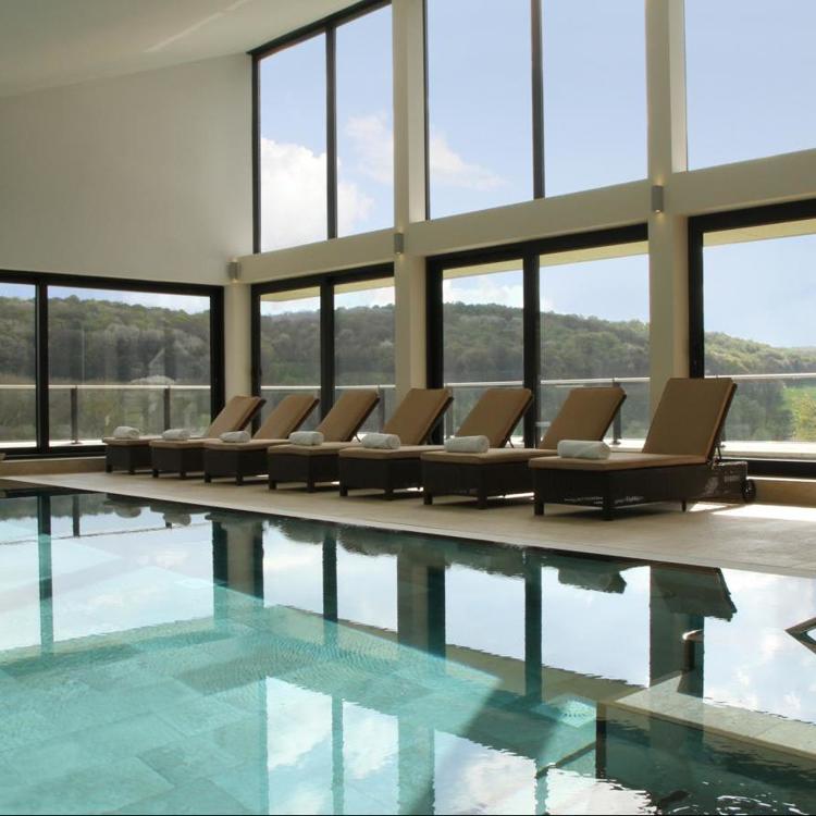 Ligbedden bij binnenzwembad en panorama uitzicht Hotel Klein Zwitserland