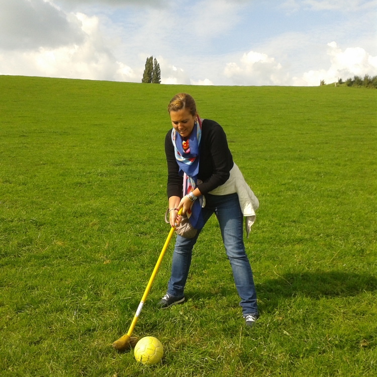 Vrouw op groot groen grasveld speelt boerengolf