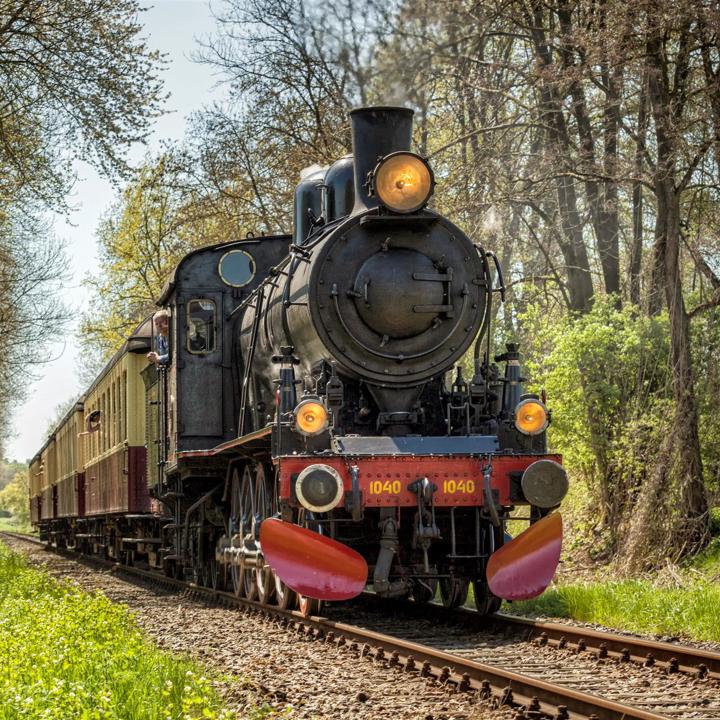 Vooraanzicht van Miljoenenlijn stoomtrein op spoor tussen bomen