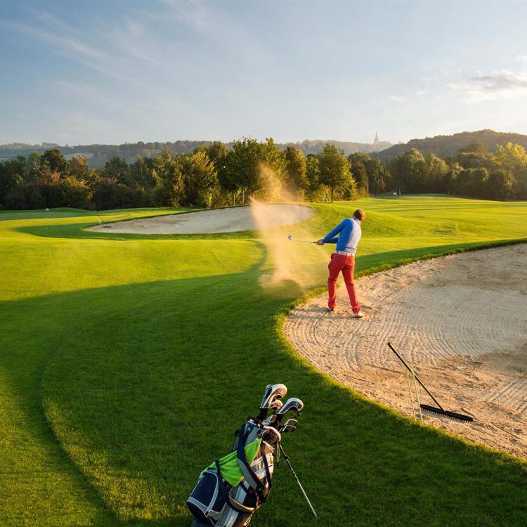 Man slaat golfbal uit bunker op golfbaan Rijk van Margraten