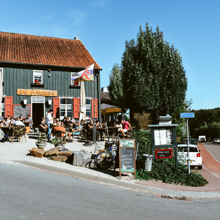 Aanzicht van Herberg de Smidse met vol terras in Epen