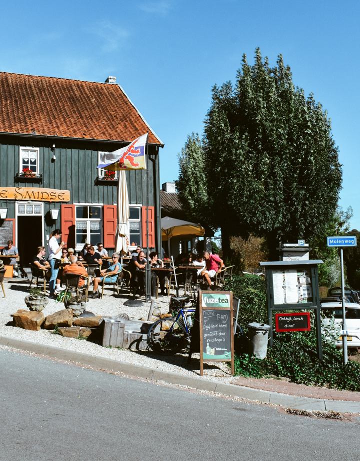 Aanzicht van Herberg de Smidse met vol terras in Epen