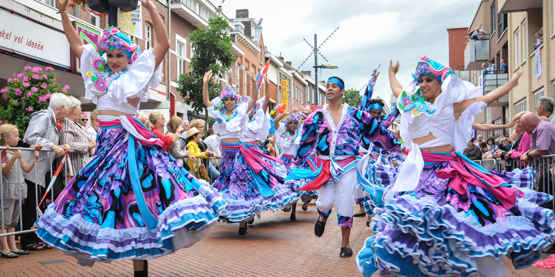 Een Latijns Amerikaanse dansgroep met zwierige rokken tijdens de Parade in Brunssum