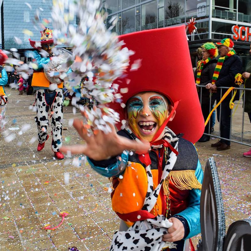 Jongetje verkleed als cowboy gooit confetti tijdens de optocht in Heerlen