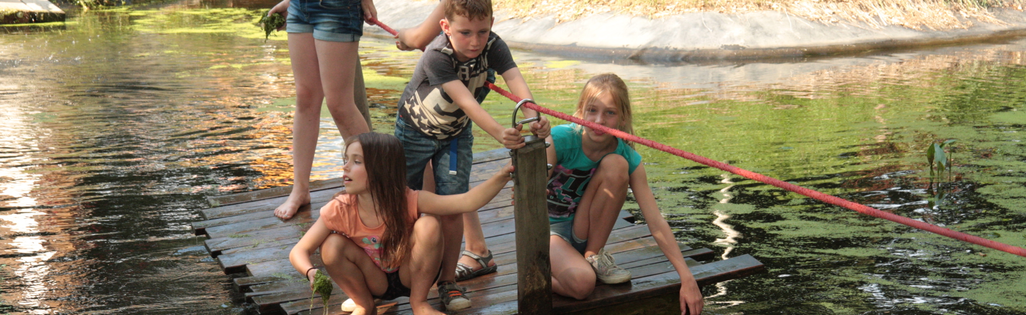 Kinderen varen over het water op een vondel