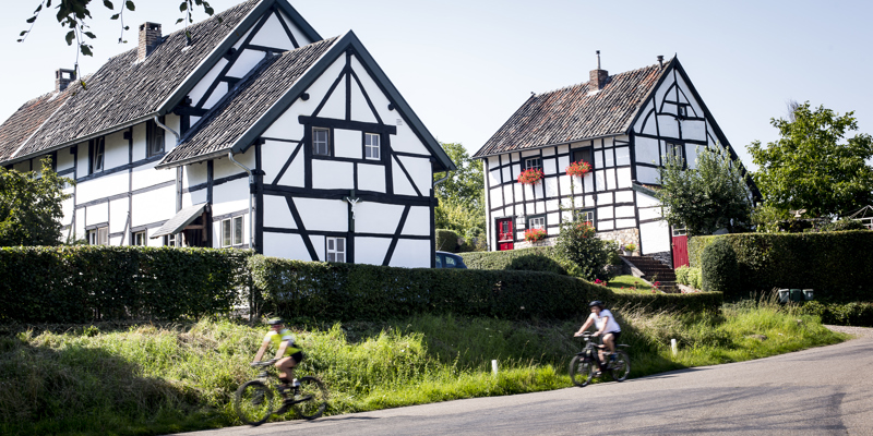 Vakwerkhuizen met voorbijrijdende fietsers