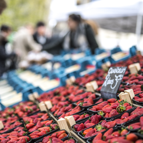 Doosjes aardbeien en asperges te koop op de markt