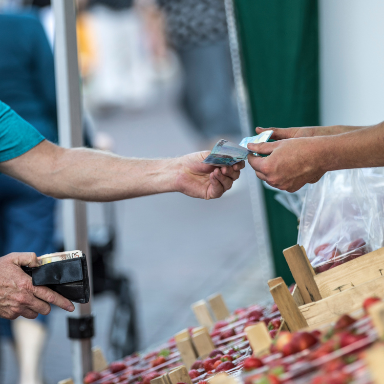 Persoon geeft 20 euro aan aardbeien verkoper