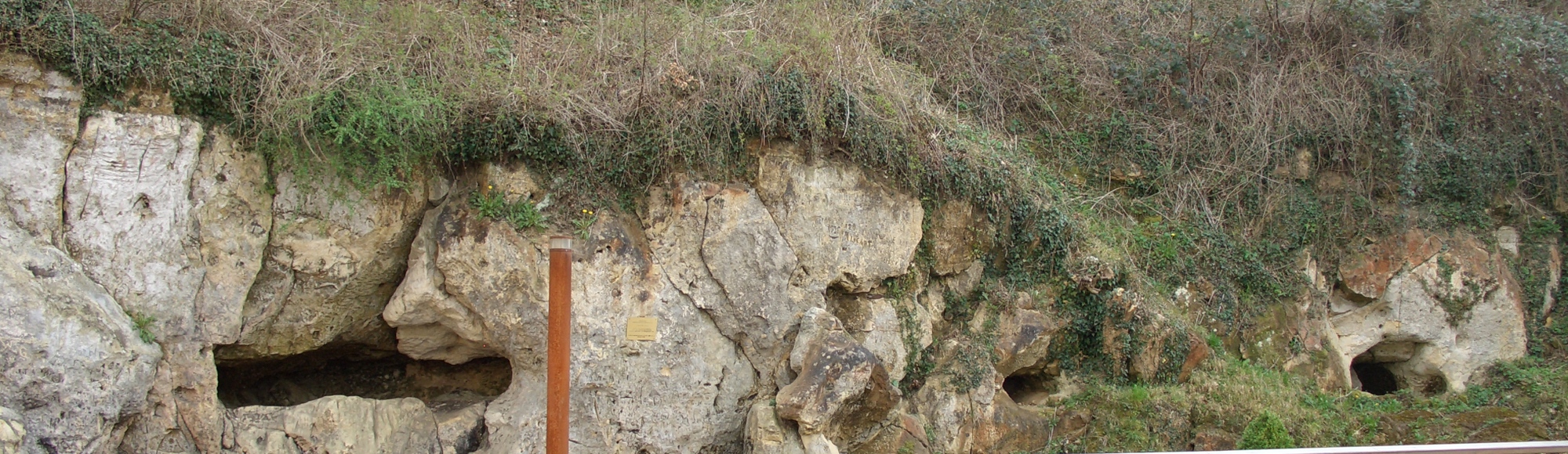 Een vooraanzicht van de vuursteenmijn in Valkenburg met gaten in de muren. 