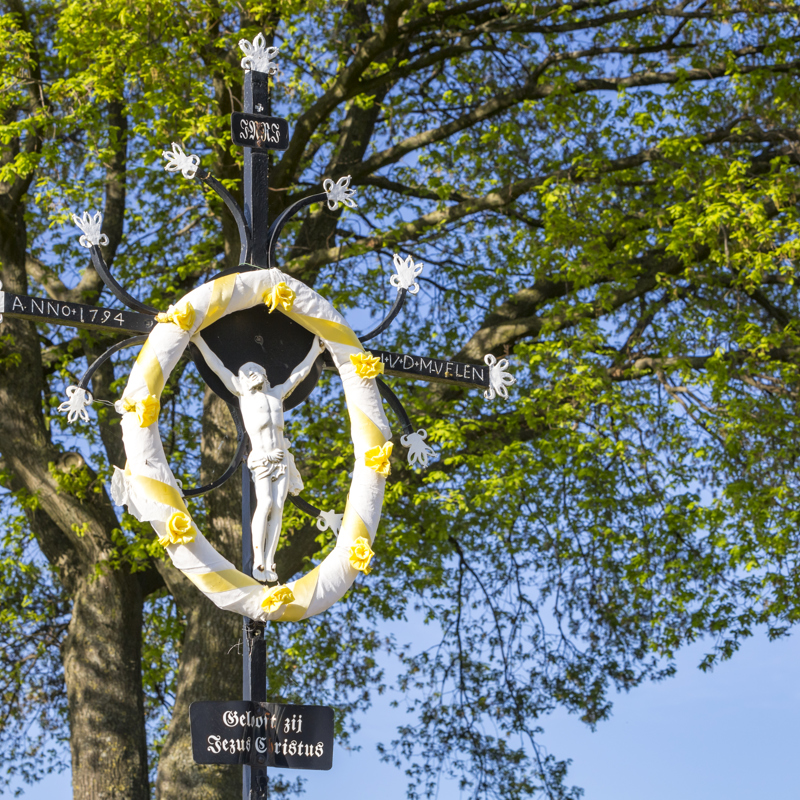 Wegkruis met geel/witte krans in Hilleshagen met achterliggende boom