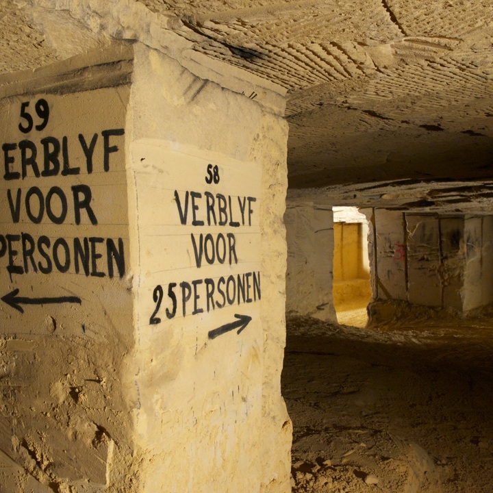 Geschreven bewegwijzering in Gemeentegrot voor verblijf in schuilkelders.