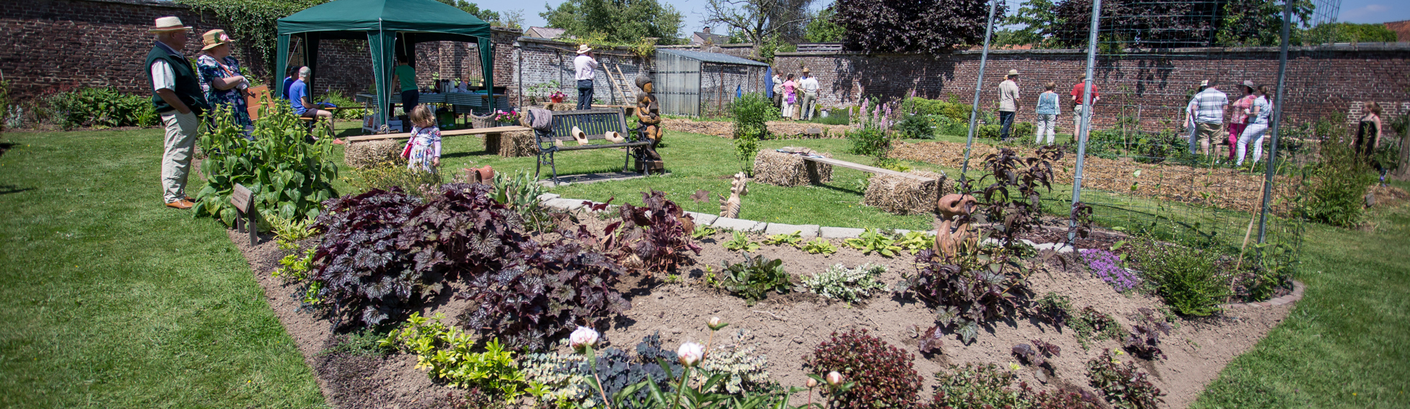 Een tuin gevuld met een aantal mensen die naar de tuin kijken