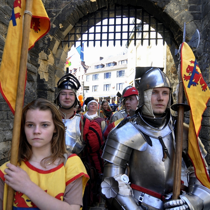 Ridders en jonkvrouwen lopen onder de Grendelpoort