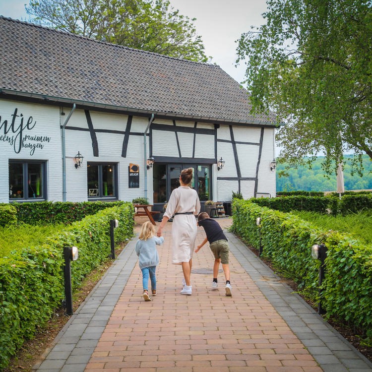 Gezin loopt richting een restaurant in een vakwerkhuis