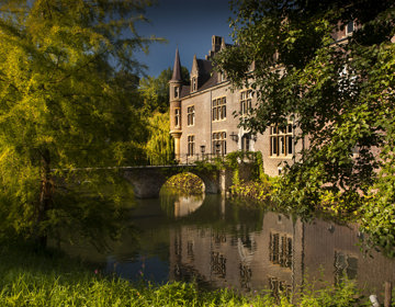 Kasteel Terworm met een brug over de gracht en natuurlijke begroeiing rondom