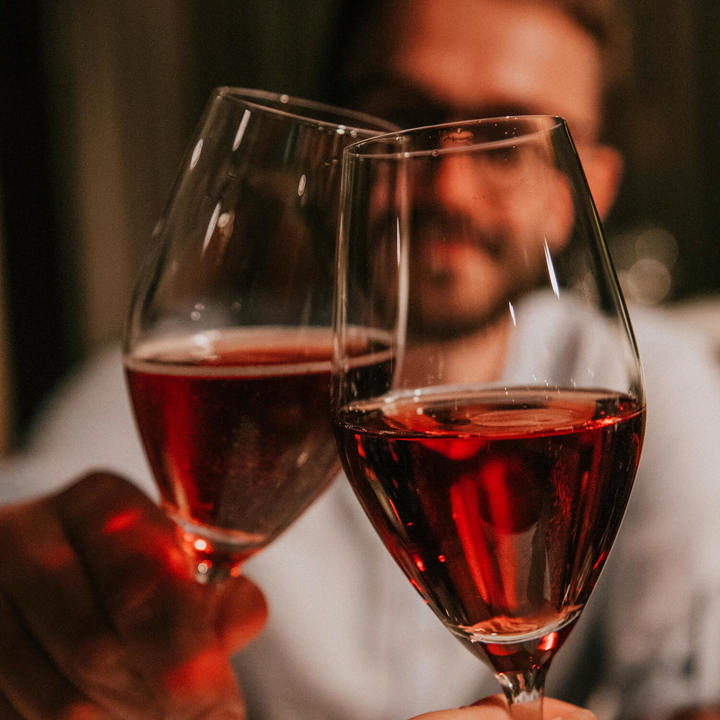 Een man en vrouw proosten met een rozige wijn bij restaurant Pirandello in Landgraaf