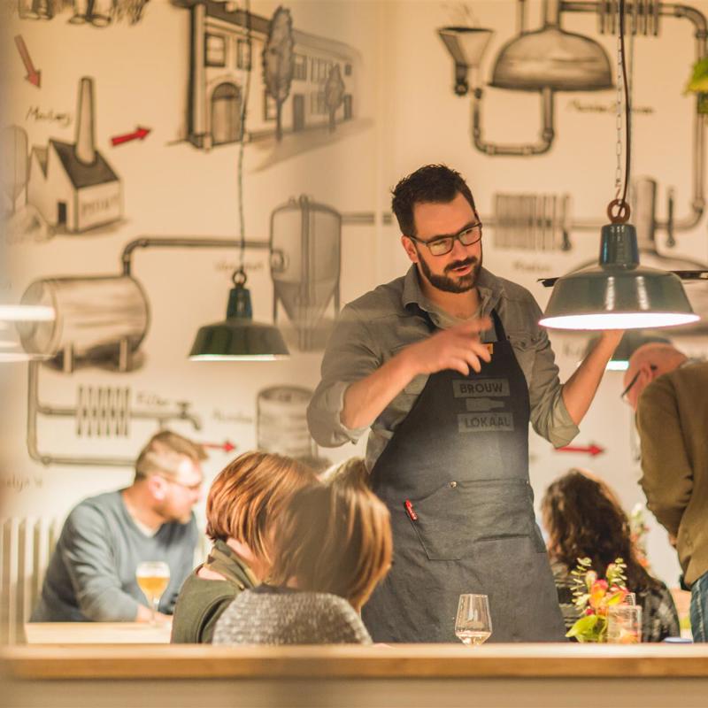 Een ober bij het Gulpener Brouwlokaal geeft uitleg bij de biertjes