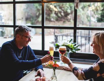 Een koppel proost met bier bij het Gulpener Brouwlokaal