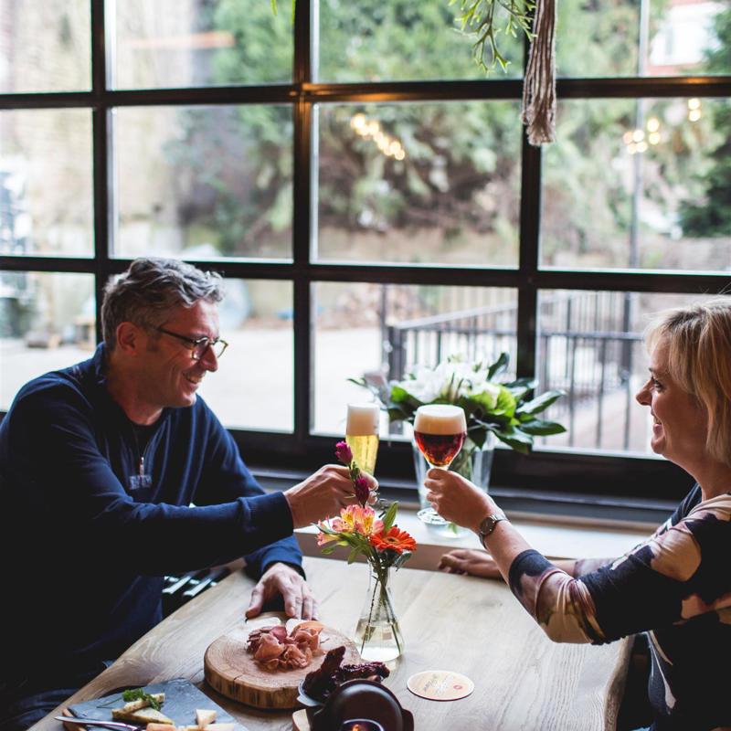 Een koppel proost met bier bij het Gulpener Brouwlokaal