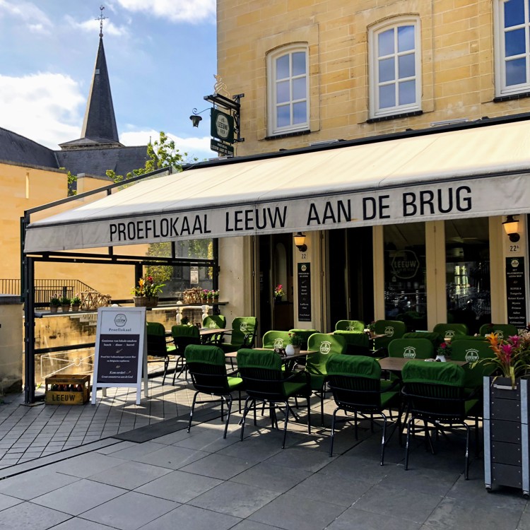 Het terras met groene stoelen aan de Geulpoort van Leeuw aan de Brug