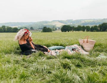 Vrouw liggende op picknickdeken met achterliggend heuvellandschap