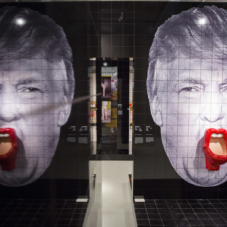 Spiegelbeeld kunstwerk van Donald Trump gemaakt uit sanitairtegels waarbij de mond een met rode lippen omlijste pisbak is