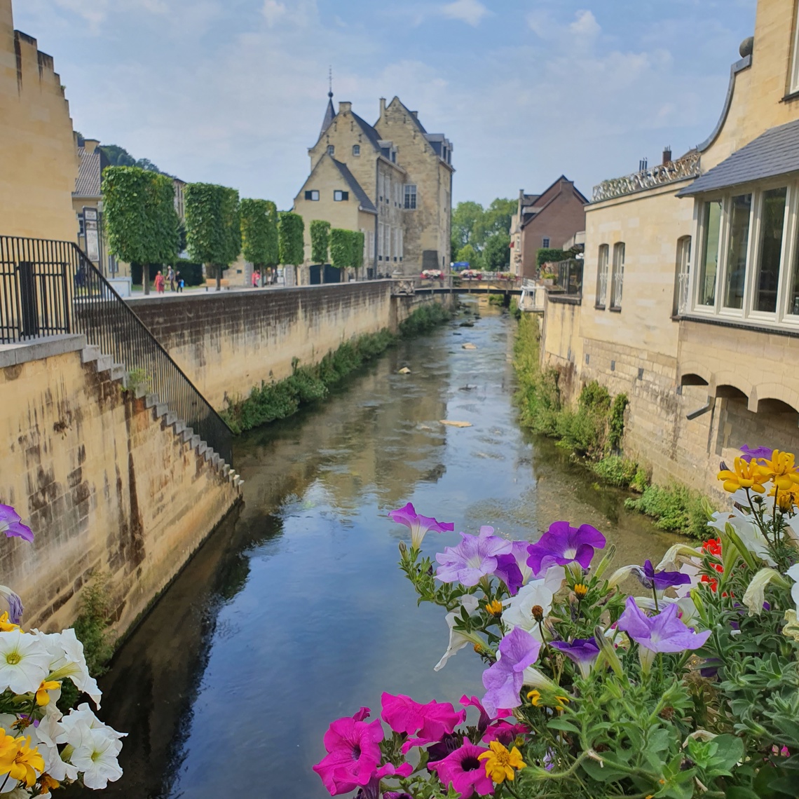 Beeld vanaf brug met bloemen bij Geulpoort over de Geul met op achtergrond Kasteel Den Halder