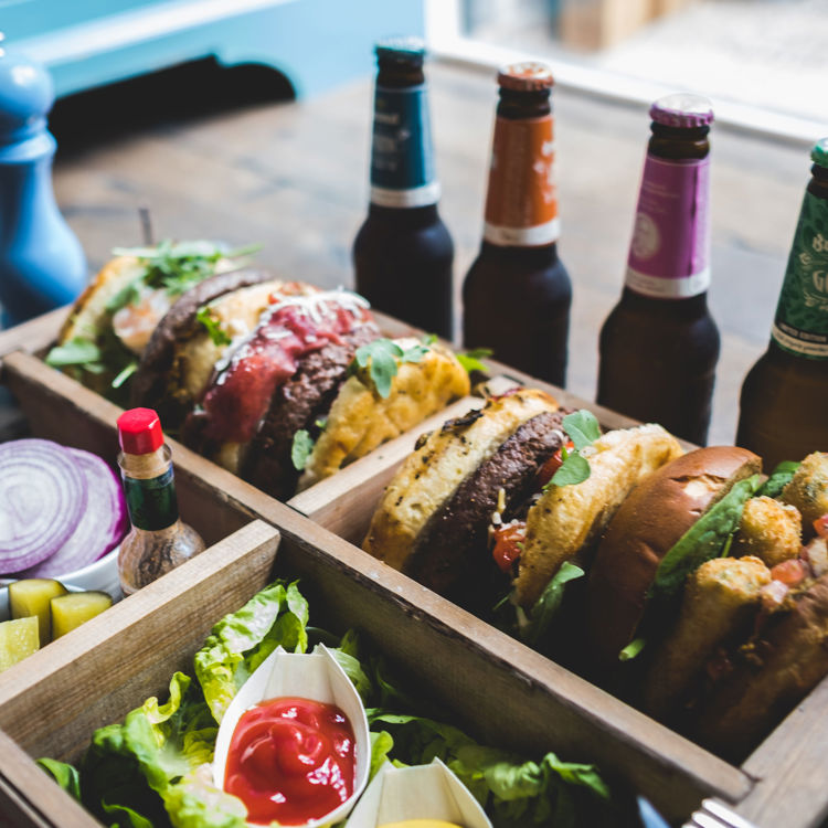 Een aantal flesjes bier en hamburgers