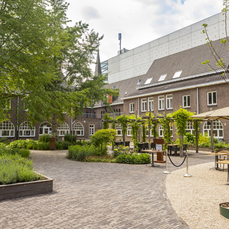 Kijkje op het Luciushof in Heerlen met terras en op de achtergrond een parkeergarage