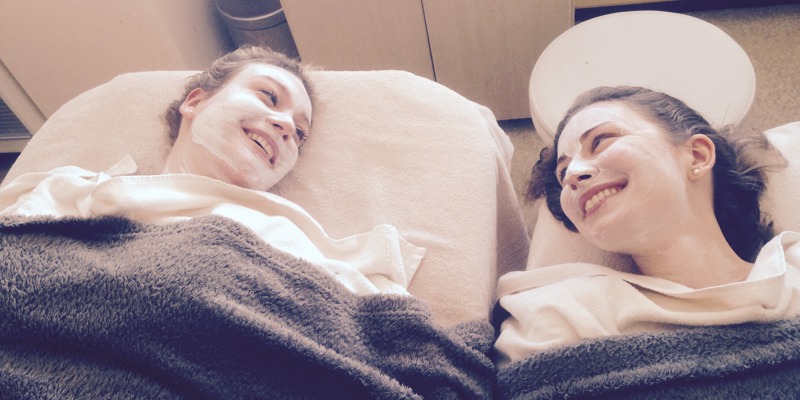 twee vrouwen tijdens een Beautybehandeling die naar elkaar lachen