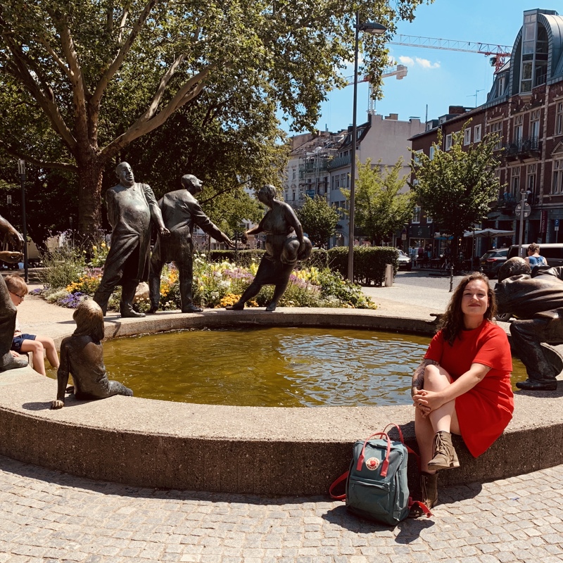 Rustende bezoeker bij de fontein met beelden in het park van Aken