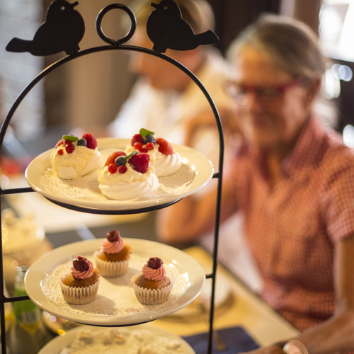 Gebakjes en gasten tijdens high tea in een café in Zuid-Limburg