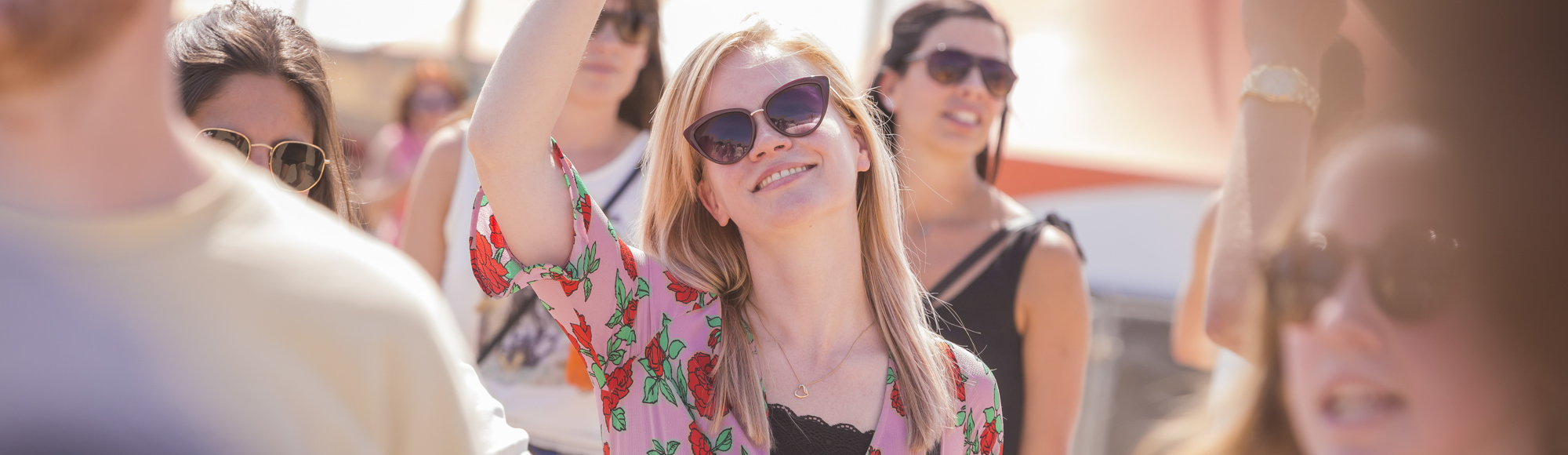 Doorkijkje naar blonde dame feestvierend op festival met biertje in haar hand