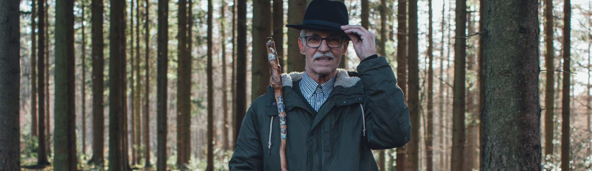 Wandelaar poseert tegen een boom in het Vijlenerbos