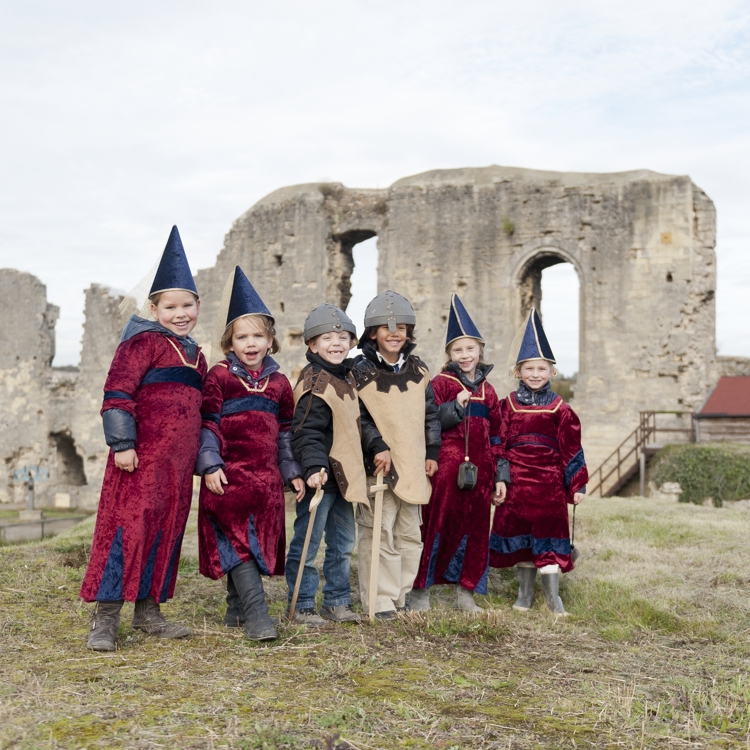 Groep kinderen staan verkleed boven op de kasteelruine in Valkenburg