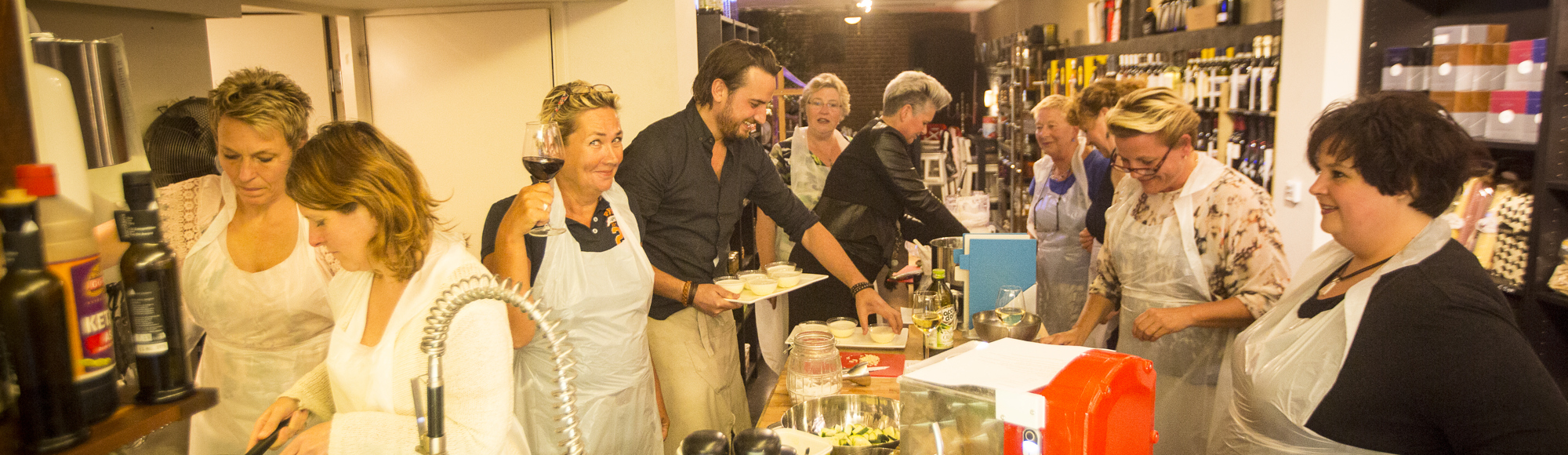 Een groep mensen is druk bezig in de keuken tijdens een kookworkshop