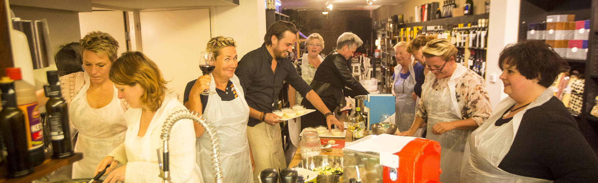 Een groep mensen is druk bezig in de keuken tijdens een kookworkshop