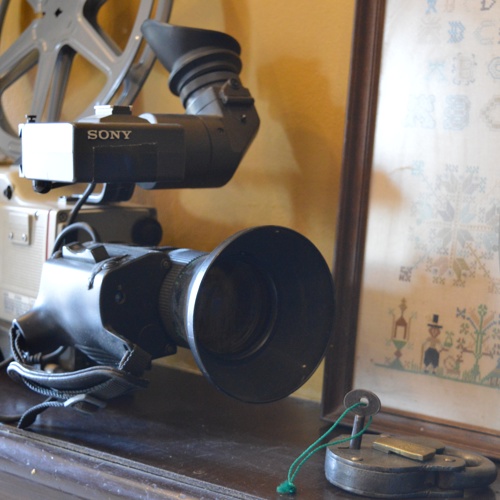 Close up van ouderwetse filmcamera met daarnaast een oud hangslot met sleutel