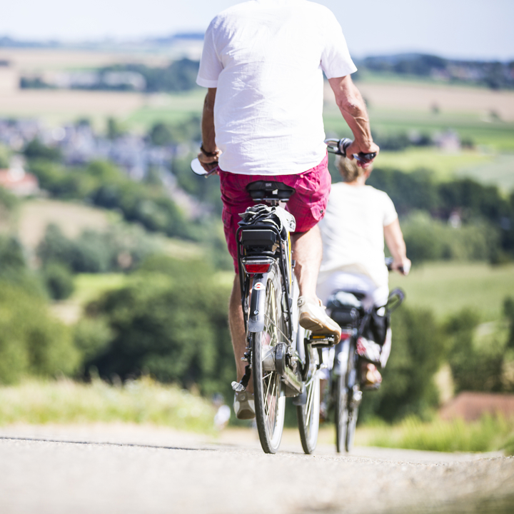 Twee fietsers met elektrische batterij achterop dalen een berg af