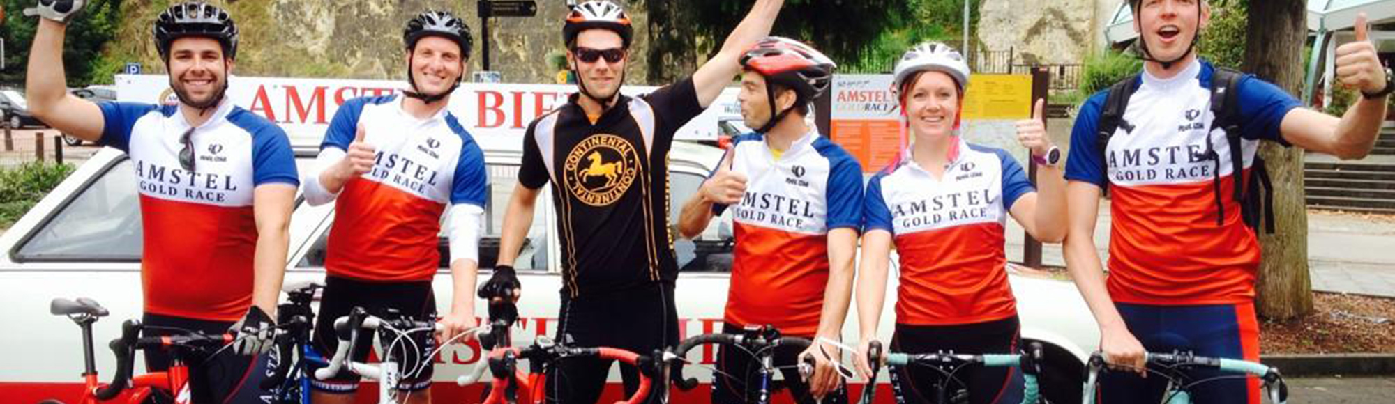 Een groep wielrenners met old-school Amstel Gold Race shirtjes voor de grotten in Valkenburg