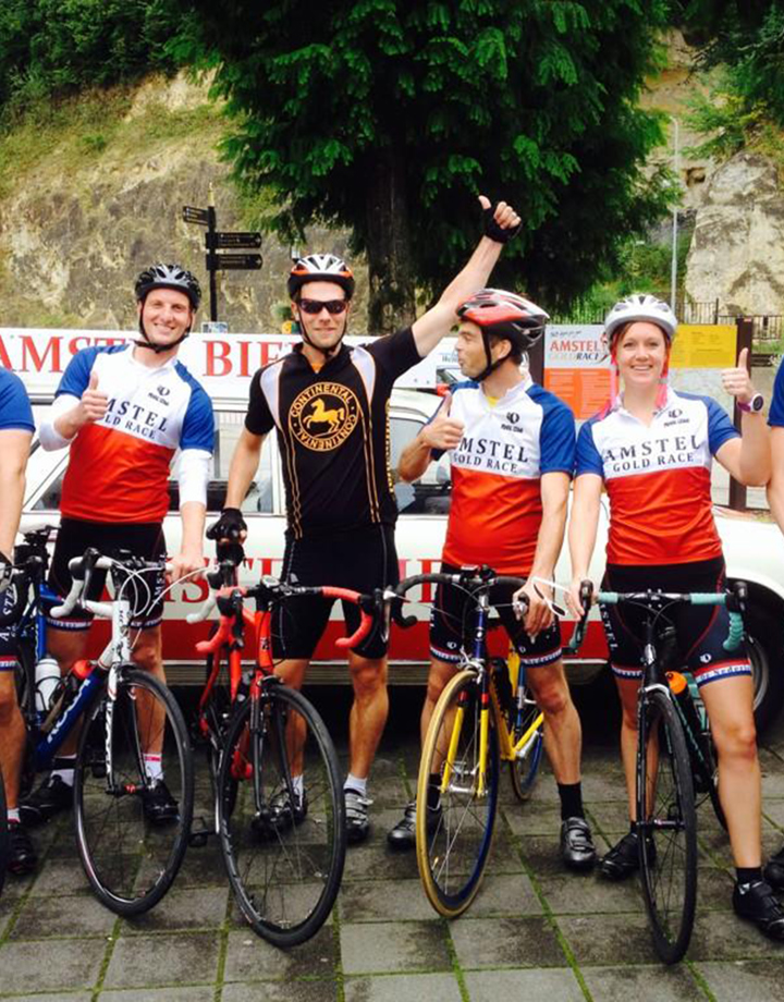 Een groep wielrenners met old-school Amstel Gold Race shirtjes voor de grotten in Valkenburg