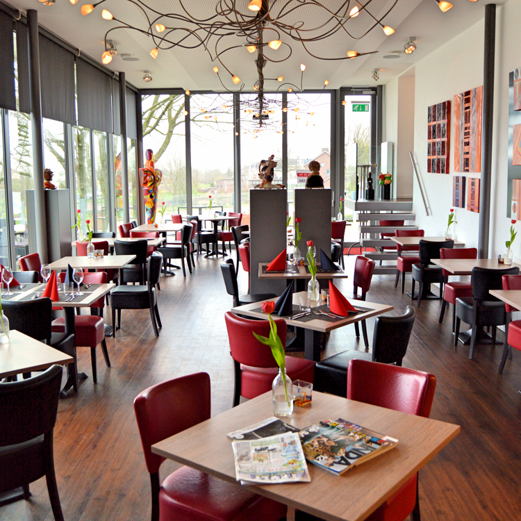 De tafelindeling met rode stoelen van Restaurant uit de Kunst