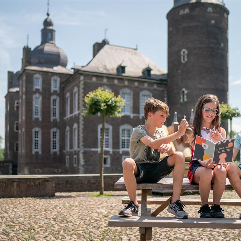 Kinderen lezen speurtocht binnenplein Kasteel Hoensbroek