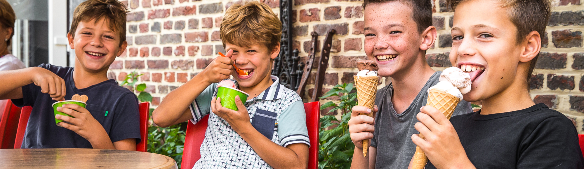 Vier tiener jongens genieten van een lekker ijsje op het terras