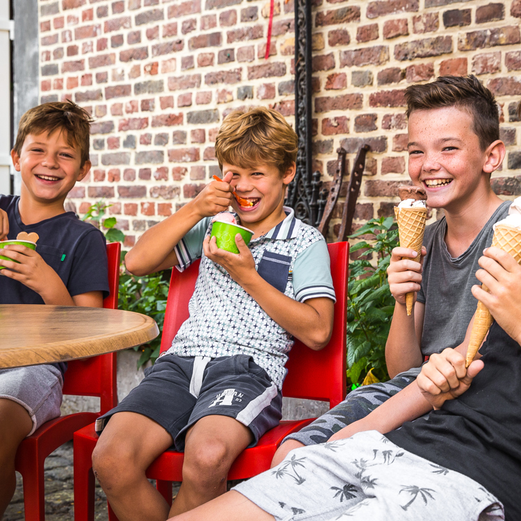 Vier tiener jongens genieten van een lekker ijsje op het terras