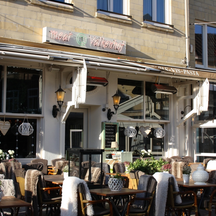 Terras van restaurant met dekentjes over de stoelen heen. 