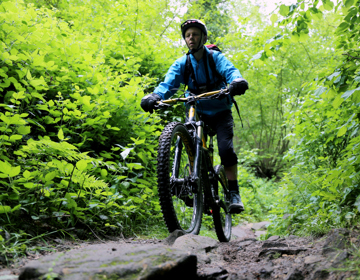 Close up van mountainbiker in fel groen bos