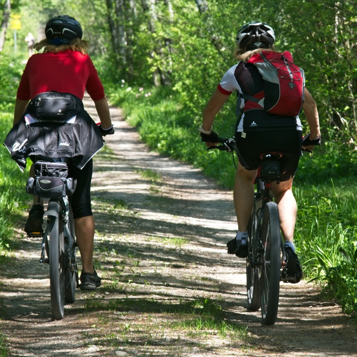 twee mountainbikers fietsen naast elkaar op onverharde bosweg