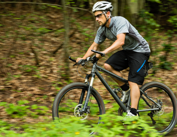 Een mannelijke MTB'er fietst over een bospad